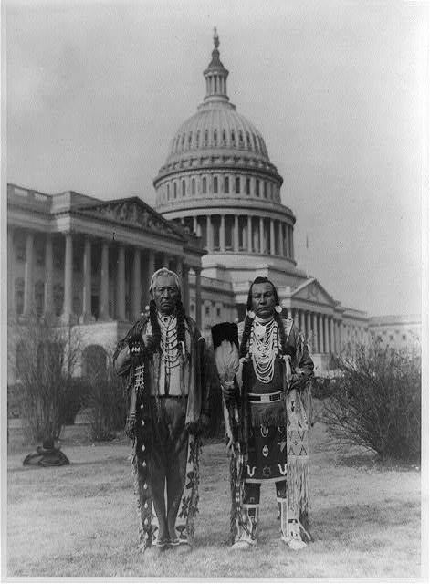 [Native American chiefs Frank Seelatse and Chief Jimmy Noah Saluskin of the Yakama tribe posed, full-length portrait, standing, facing front, with the U.S. Capitol behind them]
